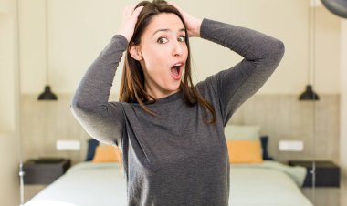 Genç ve güzel bir kadın el ele tutuşuyor, ağzı açık, son derece şanslı, şaşırmış, heyecanlı ve mutlu.