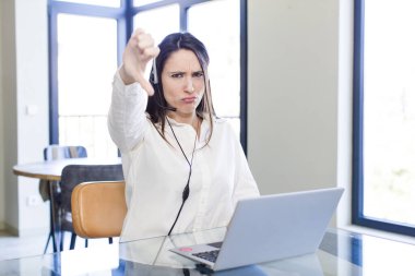 Genç ve güzel bir kadın kendini kötü hissediyor, baş parmağını kaldırıyor. tele pazarlamacı kavramı