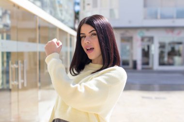 Genç ve güzel bir kadın mutlu, pozitif ve başarılı hissediyor, bir meydan okumayla karşılaştığında ya da iyi sonuçları kutladığında motive oluyor.