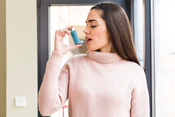 красивая молодая женщина с ингалятором от астмы. дизайн интерьера дома