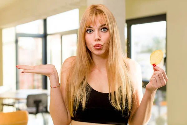 家の中でフライ不健康なジャガイモを持っている若い可愛い女性 — ストック写真