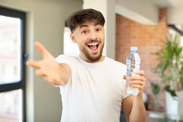 Молодой Красивый Мужчина Счастливо Улыбается Предлагает Показывает Концепцию Бутылка Водой — стоковое фото
