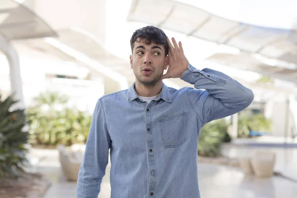 Joven Guapo Hombre Buscando Serio Curioso Escuchando Tratando Escuchar Una —  Fotos de Stock