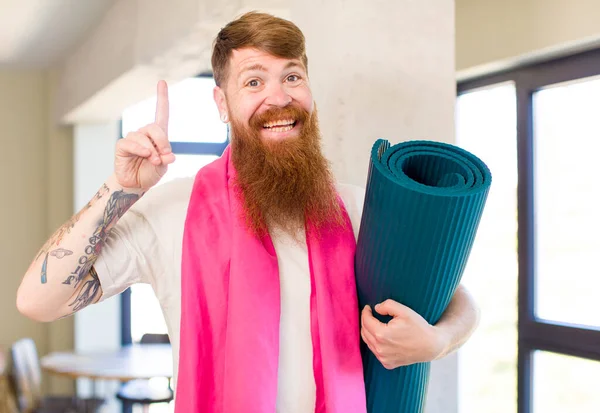 红头发的男人在意识到一个瑜伽垫的想法后 觉得自己是个快乐而兴奋的天才 健身概念 — 图库照片