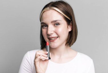 young pretty woman using a lipstick bar. making up concept
