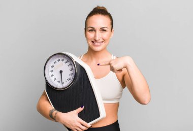 Terazisi olan genç ve güzel bir kadın. diyet ve fitness kavramı