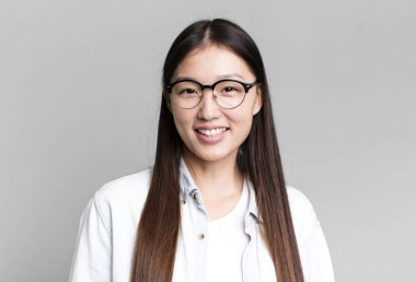 Genç, güzel, Asyalı, etkileyici bir kadın. Yanında fotokopi odası var.