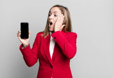 Güzel sarışın kadın mutlu, heyecanlı ve şaşırmış hissediyor. İş kadını ve telefon konsepti