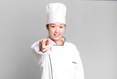 Güzel Asyalı kadın kamerayı göstererek seni seçiyor. restoran şefi konsepti