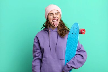 hispanic pretty woman with cheerful and rebellious attitude, joking and sticking tongue out. skate boarding concept