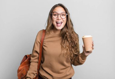 İspanyol güzel kadın mutlu ve hoş bir şekilde şaşırmış görünüyor. kahve konseptini kaldır.