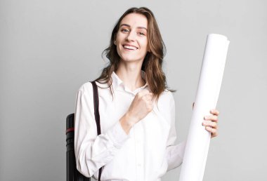 young pretty woman feeling happy and facing a challenge or celebrating. architect concept