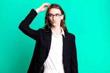 Genç ve güzel bir kadın mutlu bir şekilde gülümsüyor ve hayal kuruyor ya da şüphe ediyor. iş kavramı