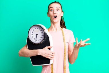 Genç ve güzel bir kadın inanılmaz bir sürprizle şaşkına döndü ve hayrete düştü. fitness ve diyet konsepti