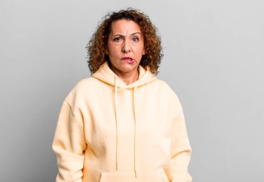 Orta yaşlı İspanyol bir kadın hangi seçeneği seçeceğine karar veremiyor, bilgisiz, kafası karışık ve kararsız hissediyordu.