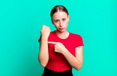 Sabırsız ve kızgın görünüyor, saatine bakıyor, dakiklik istiyor, zamanında gelmek istiyor.