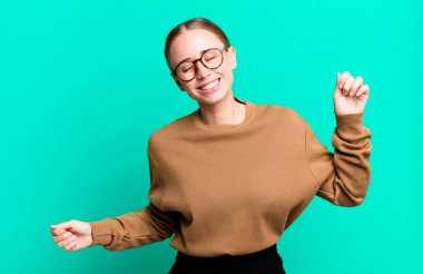 Gülümsüyor, kaygısız hissediyor, rahat ve mutlu, dans ediyor ve müzik dinliyor, bir partide eğleniyor.