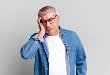 Orta yaşlı bir adam yorgun, sıkıcı ve sıkıcı bir işten sonra sıkılmış, hayal kırıklığına uğramış ve uykulu hisseder.
