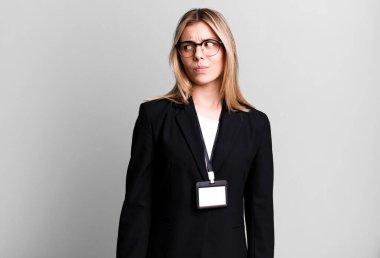 Genç, güzel bir kadın üzgün, üzgün ya da kızgın hissediyor ve yan tarafa bakıyor. kimlik kartı akreditasyon kavramı