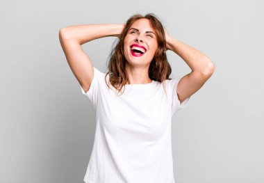 Genç ve güzel bir kadın gülümsüyor ve rahatlıyor, tatmin oluyor ve kaygısız, neşeli ve rahatlatıcı.