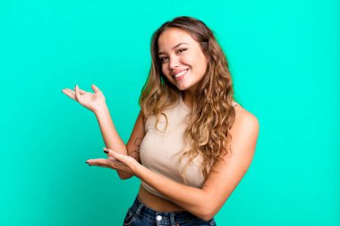 Genç ve güzel bir kadın gururla ve güvenle gülümsüyor, mutlu ve tatmin olmuş hissediyor ve fotokopi alanında bir konsept gösteriyor.