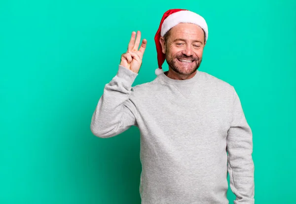 中年男性の笑顔と友好的に見える 3番目を示す クリスマスのコンセプト — ストック写真
