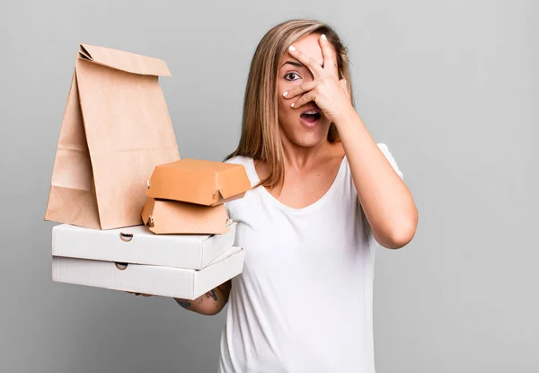 かなりブロンドの女はショックを受けて怖がってる手で顔を覆ってる 配送は食品パッケージの概念を取り除き — ストック写真