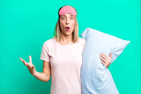 stock image pretty blonde woman feeling extremely shocked and surprised. pajamas and nightwear concept