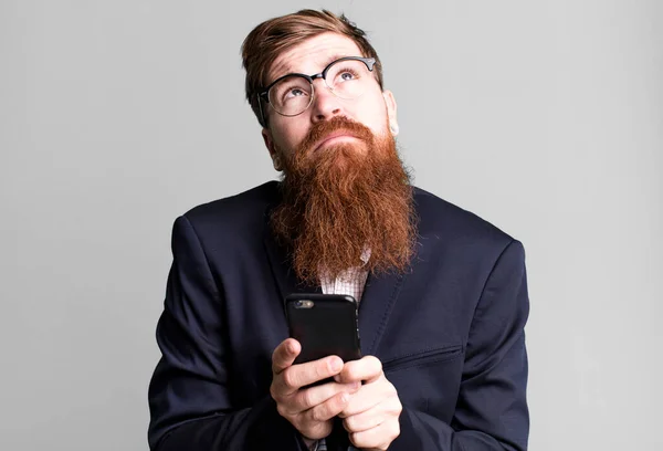 年轻的红头发 留着胡子 很酷的商人用他的智能手机 — 图库照片