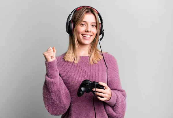 stock image young pretty woman feeling shocked,laughing and celebrating success. gamer with headset and controller