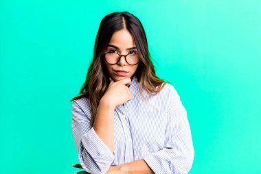 İspanyol güzel kadın ciddi görünüyor, kafası karışık, kararsız ve düşünceli, seçenekler veya seçimler arasında şüpheci.