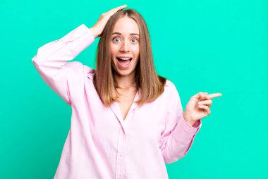 Gülüyor, mutlu, pozitif ve şaşırmış görünüyor. Yan fotokopi alanını işaret eden harika bir fikri fark ediyor.