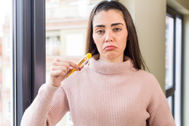 Termometresi olan genç ve güzel bir kadın. Hastalık konsepti ev iç tasarımı