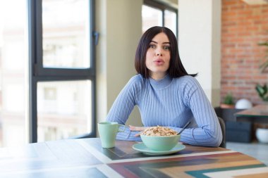 Güzel genç bir kadın son derece şaşkın ve şaşırmış hissediyor. kahvaltı kavramı