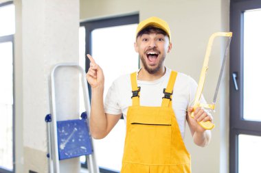 Genç yakışıklı bir adam bir fikri fark ettikten sonra mutlu ve heyecanlı bir dahi gibi hissediyor. Testereli tamirci.