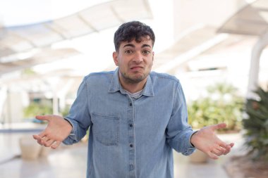 Genç yakışıklı bir adam bilgisiz ve kafası karışık, hiçbir fikri yok, aptal ya da aptal bir bakışla tamamen kafası karışmış.