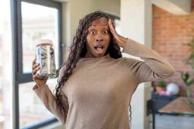 Siyah afro kadın mutlu, şaşkın ve şaşırmış görünüyor. Tasarruf konseptiyle