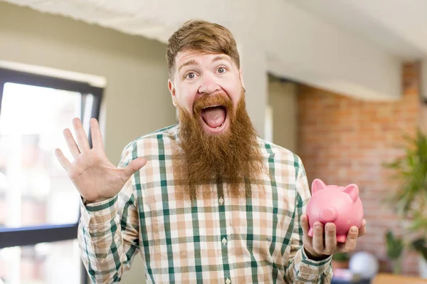 Ruda Włosy Człowiek Uczucie Szczęśliwy Zdumiony Coś Niewiarygodnego Świnka Bank — Zdjęcie stockowe