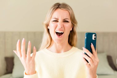 Akıllı telefon kullanan güzel bir genç bayan. ev iç tasarımı