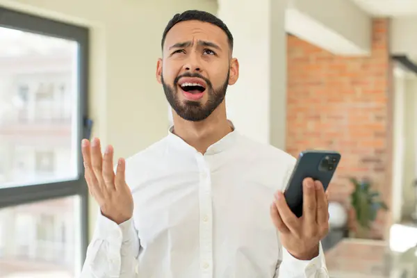 Een Jonge Volwassen Man Schreeuwt Met Zijn Handen Omhoog Smartphone — Stockfoto