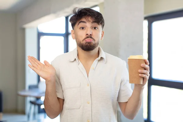 Mladý Pohledný Muž Pokrčil Rameny Cítil Zmatený Nejistý Odnést Kávu — Stock fotografie