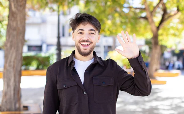 Young Handsome Man Smiling Happily Cheerfully Waving Hand Welcoming Greeting — Stock Photo, Image