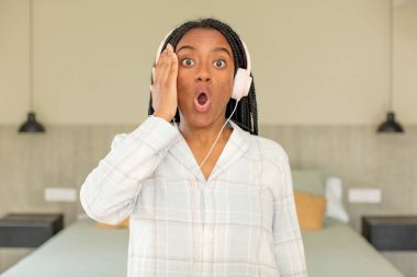 Siyah afro kadın şok olmuş ve şaşırmış hissediyor. dinlenme ve gecelik konsepti