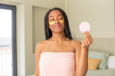 Siyah afro kadın gülümsüyor ve mutlu ve kendinden emin bir ifadeyle bakıyor. güzellik konsepti