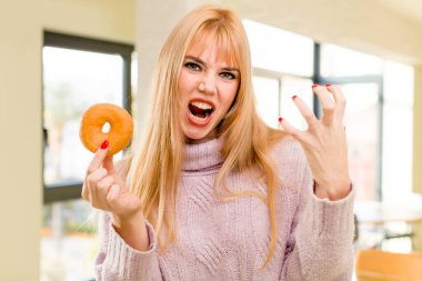 Donutlu genç ve güzel bir kadın. İç mekanda sağlıksız diyet kavramı