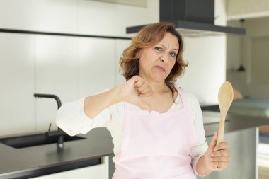 Orta yaşlı, güzel bir kadın kendini kötü hissediyor. ev konseptinde yemek yapmak