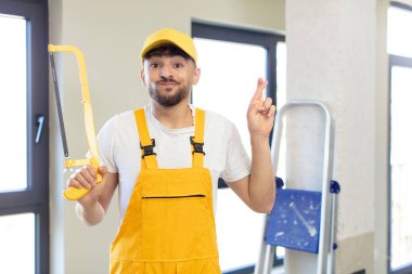 Genç yakışıklı adam şans diliyor ve şans diliyor. Testereli tamirci.