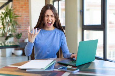 Kızgın, sinirli ve hayal kırıklığına uğramış görünüyor. dizüstü bilgisayar ve masa konsepti