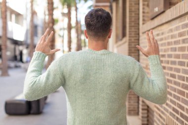 Genç ve yakışıklı bir adam elleri havada öfkeli, sinirli, stresli ve üzgün hissediyor.