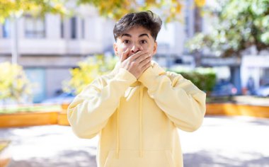 Şok olmuş, şaşırmış bir ifadeyle ağzı kapalı genç yakışıklı bir adam sır saklıyor ya da 